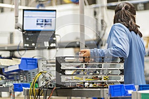 Rear view of female technician repairing computer