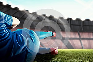 Rear view of a football player man in a blue jersey tackling the ball