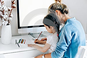 Rear view of a freelacer businesswoman using desktop computer in the office. Pretty young blonde woman sit indoors at home working