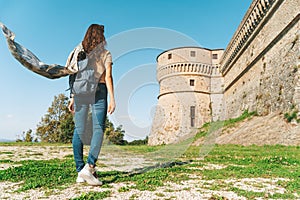 Rear view of a girl discovering medieval castle in Italy