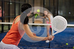 Rear view of girl with racket playing padel