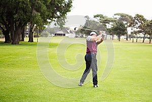 Rear view of golfer raising his golf club