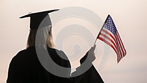 Rear view of graduate woman with usa flag in hand