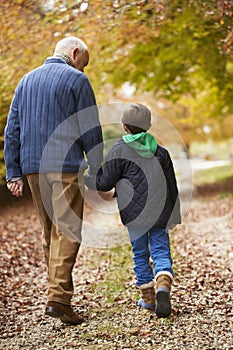 Rear View Of Grandfather And Grandson Walking Along Path