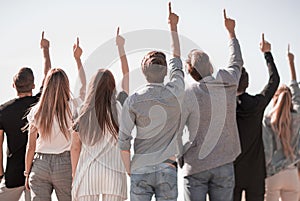 Rear view. a group of business youth pointing up at a copy space