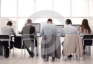 Rear view.a group of call center employees sitting at the Desk.