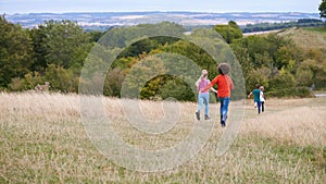 Rear View Of Group Of Children On Outdoor Activity Camping Trip Running Down Hill