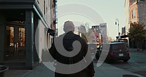 Rear view of handsome stylish male blogger walking in suburban streets in New York City