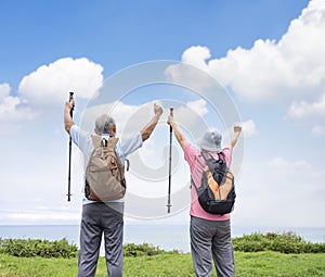 Rear view of Happy Senior couple hiking together on the mountain and coast