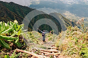 Rear view of a hiker on a wooden ladders at Mount Sabyinyo, Uganda