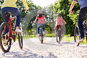 Rear View Of Hispanic Family On Cycle Ride