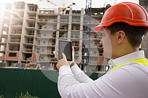 Rear view image of male building worker using digital tablet on construction site