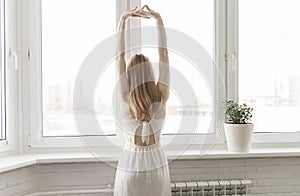 Rear view image of a woman do stretching after waking up in the morning