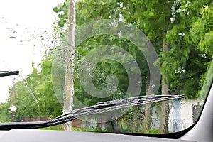 Rear view from inside mirror rain water drops falling on car window windshield glass