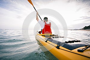 Rear view of kayaker paddling