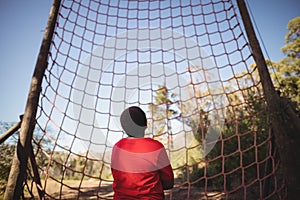 Rear view of kid looking at net during obstacle course