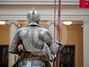 Rear view of a knight wearing 16th century German plate armor while holding a lance