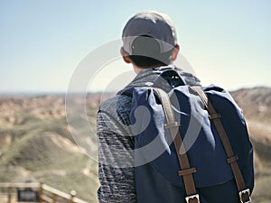 Rear view of male asian tourist backpacker looking at view in national park