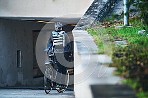 A rear view of male bicycle courier delivering packages in city. Copy space.