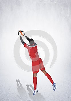 Rear view of male goalkeeper making a save against copy space on grey background