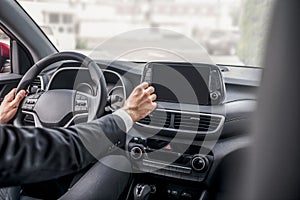 Rear view of male hands adjusting car settings