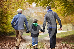 Rear View Of Male Multl Generation Family Walking On Path