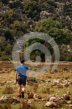 rear view of male tourist on the background of mountain with green trees