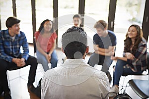 Rear View Of Male Tutor Leading Discussion Group Amongst High School Pupils photo