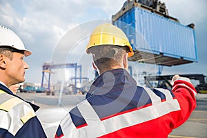 Rear view of male workers discussing in shipping yard