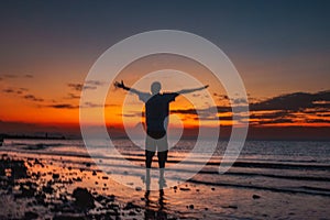 Rear view of a man at the beach against a golden sunset at Lake Turkana, Northern Kenya