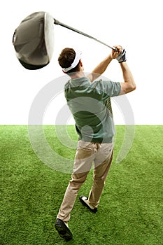 Rear view of man completing golf swing n mid follow-through with focus on club against white studio background.