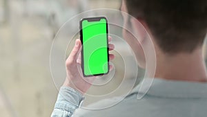 Rear View of Man Lookin at Smartphone with Chroma Screen