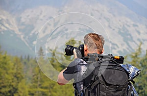 Rear view of man photographer in mountains