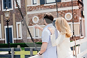 rear view of man pointing on something to woman