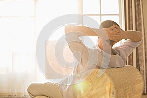 Rear view of man relaxing on chair at home