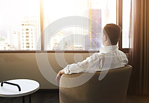 Rear view of man relaxing on chair in the room