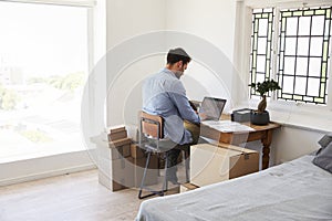 Rear View Of Man Running Business From Home Dispatching Goods