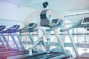 Rear view of man running on treadmill