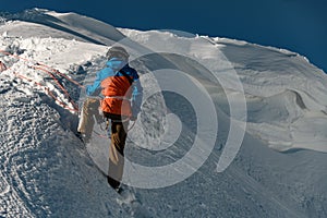 rear view of man in ski suit holding rope on mountain slope