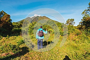 Rear view of a man standing against the background Mount Sabyinyo in the Mgahinga Gorilla National Park, Uganda