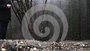 Rear view of a man standing in front of autumn forest under the rain. Stock footage. Cold autumn weather and foggy wet