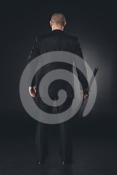 rear view of man in suit with katana sword