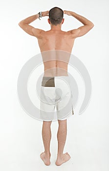 Rear view of man in swimming trunks looking far