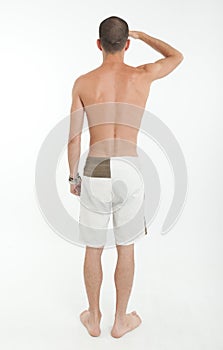 Rear view of man in swimming trunks looking far