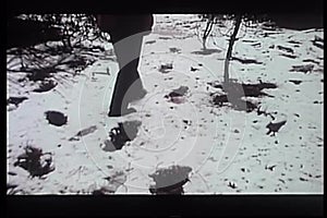 Rear view of man tracking trail of big footprints in snow