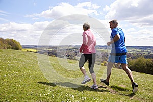 Rear View Of Mature Couple Jogging In Countryside