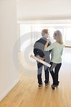 Rear View Of Mature Couple Standing In New House