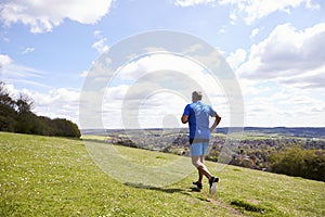 Rear View Of Mature Man Jogging In Countryside