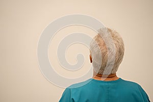 Rear view of a medical doctor or nurse glancing at a white wall