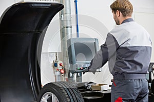 Rear view of mid adult automobile mechanic working in workshop